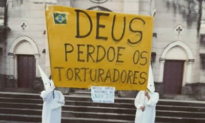 Fotos mostram duas pessoas com vestes semelhantes às usadas por adeptos da organização terrorista e supremacista Ku Klux Klan, segurando