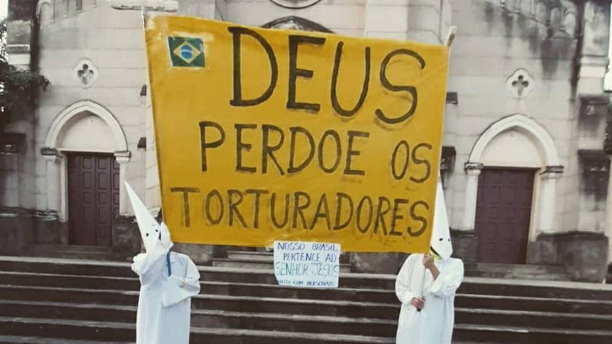 Fotos mostram duas pessoas com vestes semelhantes às usadas por adeptos da organização terrorista e supremacista Ku Klux Klan, segurando