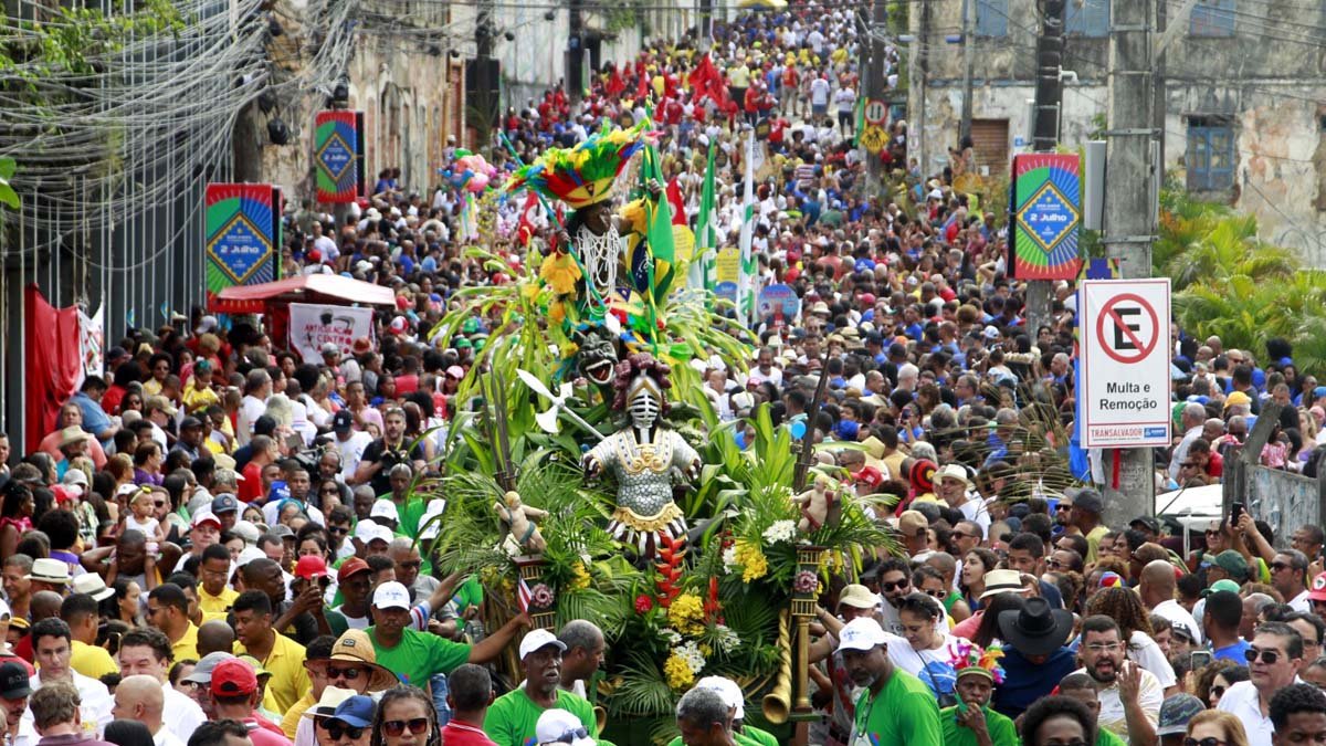 Com muita alegria estampada nos rostos, crianças, idosos, estudantes, homens, mulheres participam do cortejo do 2 de Julho. 